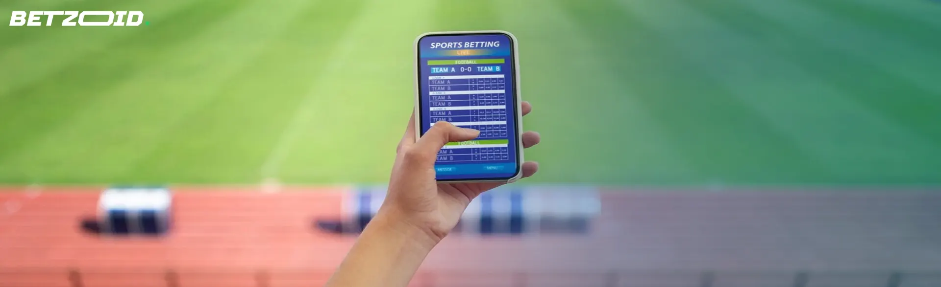 A hand holds a phone displaying soccer betting apps at a stadium.