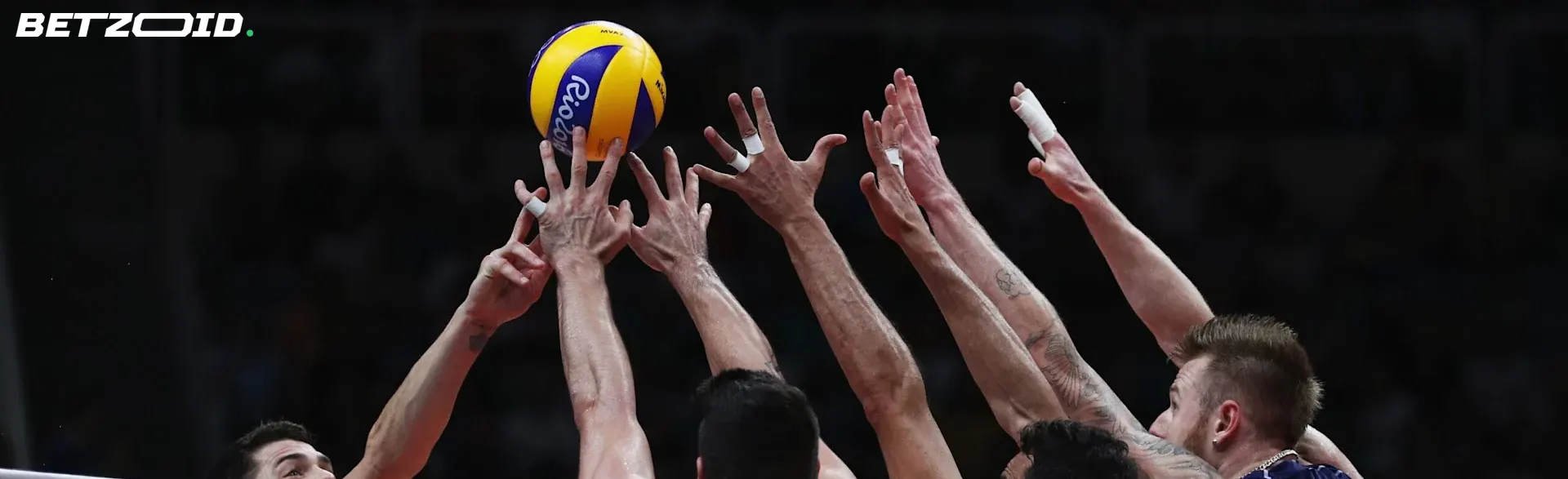 Volleyball players reaching for the ball during a match, symbolizing the diverse sports events available on Alberta sports betting sites.
