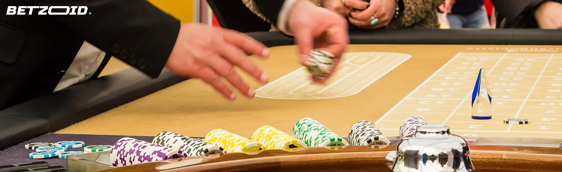Players placing bets at a casino table with chips and cards visible, emphasizing the excitement of live casino gaming.