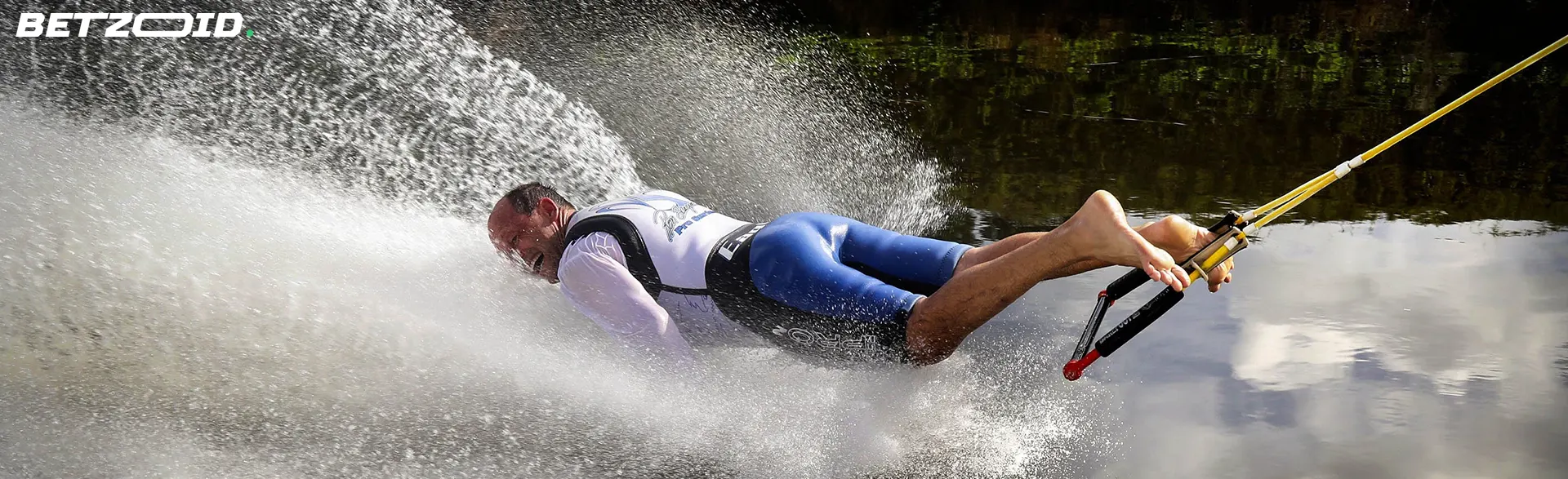 A man waterskiing and falling with water splashing around, representing the best sports betting sites in Ontario.