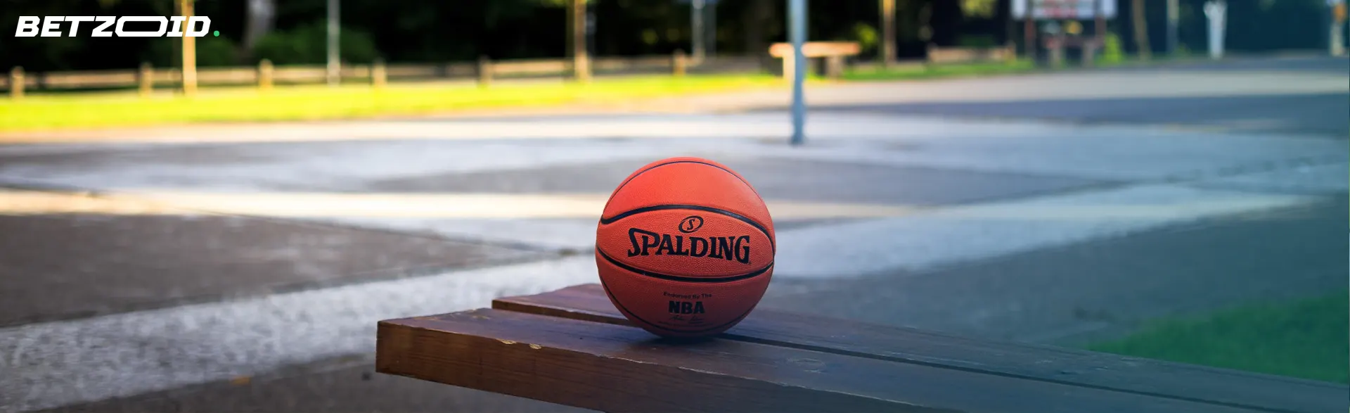 The image shows basketball resting on a wooden bench.