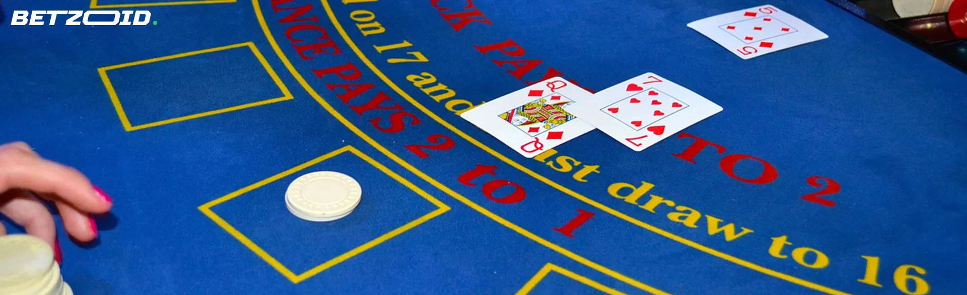A close-up view of a blackjack table with cards showing a king and an ace, chips.