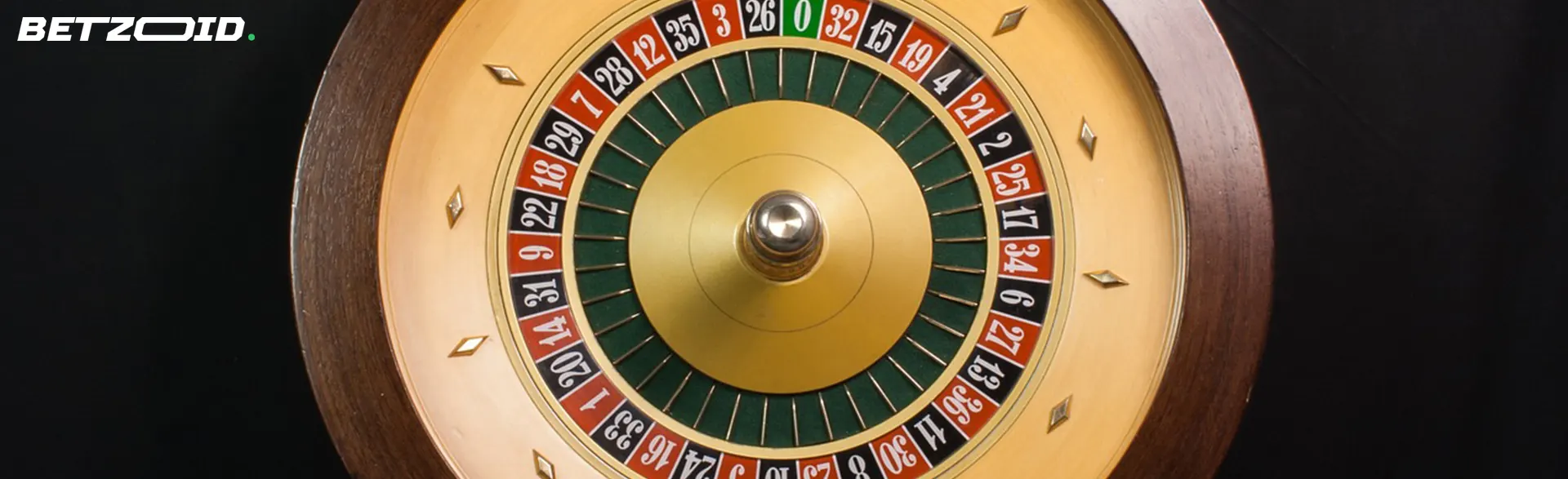 A close-up view of a roulette wheel with numbers and a single zero, set against a dark background.