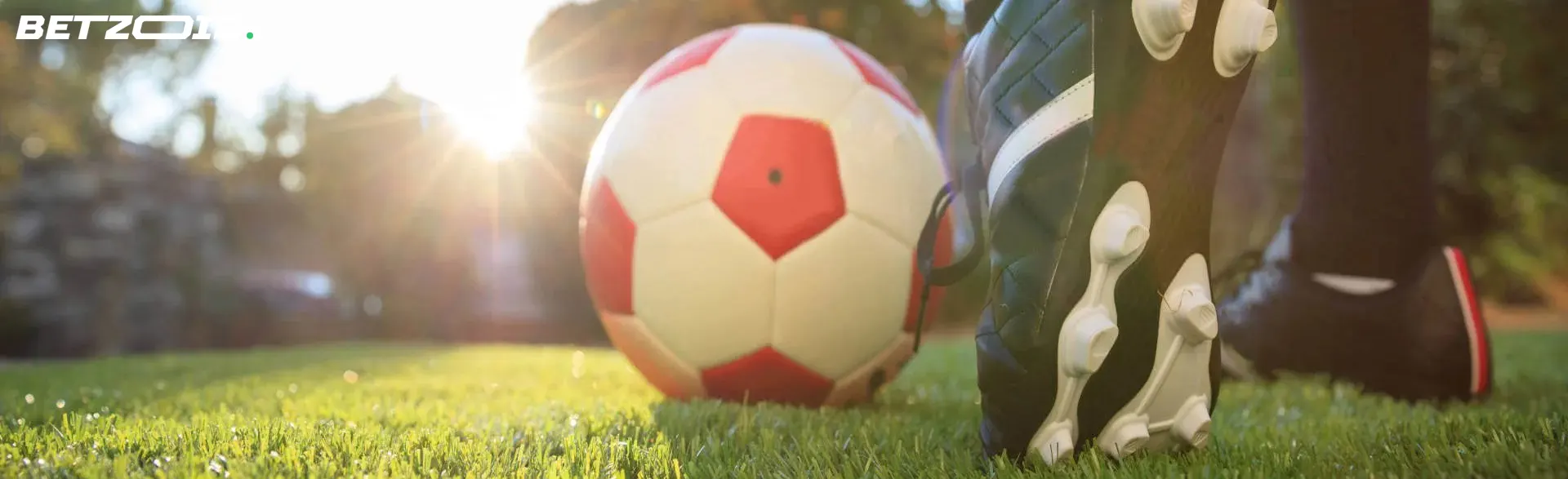 Close-up view of a soccer ball on a grassy field with a player's foot about to kick it, symbolizing Manitoba sports betting sites.