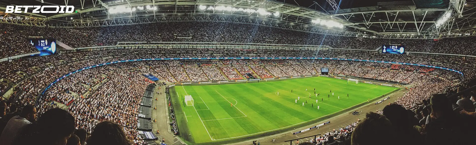A panoramic view of a vibrant football stadium during a match, packed with enthusiastic fans.