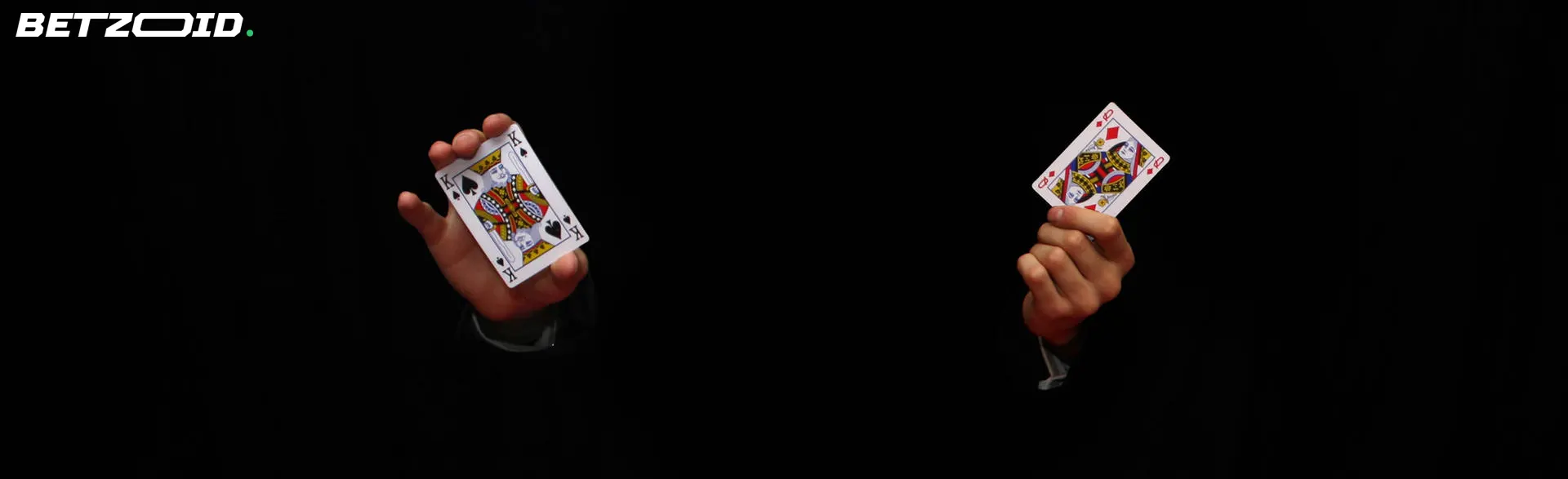 A pair of hands holding two face cards from a deck, symbolizing the excitement of playing baccarat at the best Canadian online casinos.