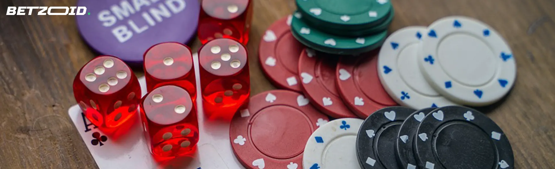 Red dice and assorted casino chips on a wooden surface, symbolizing no deposit casino gaming opportunities.
