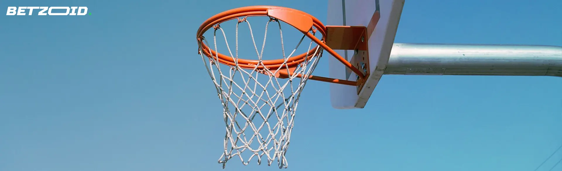 Basketball hoop against a clear blue sky.