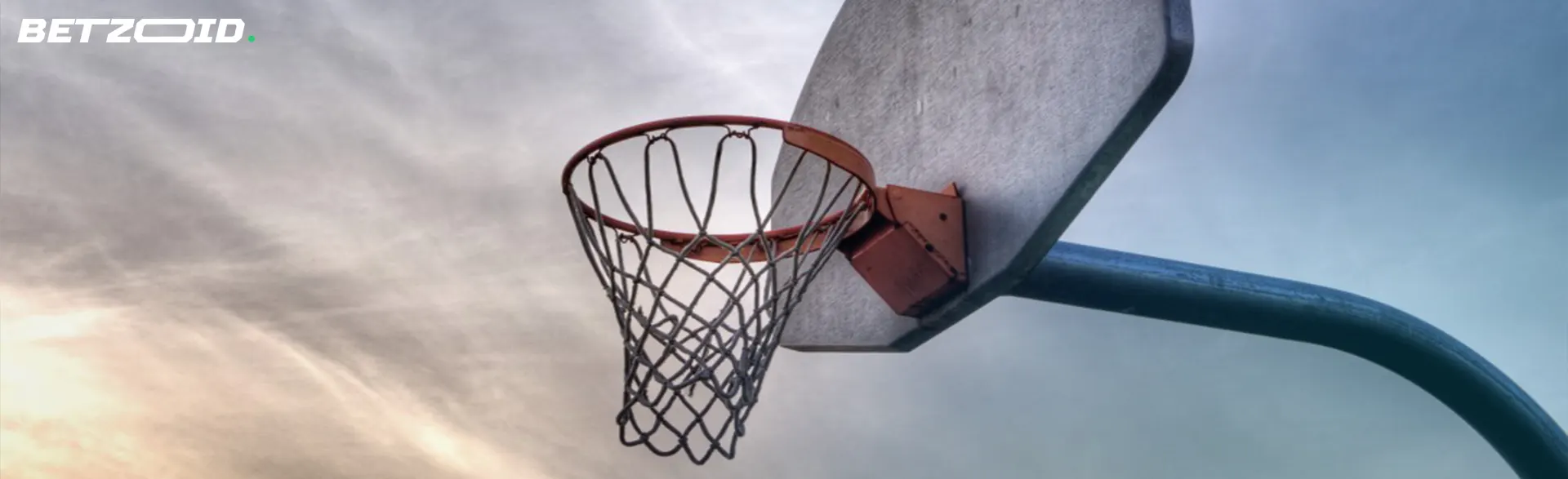 A basketball hoop against a cloudy sky backdrop, symbolizing outdoor sports and recreation.