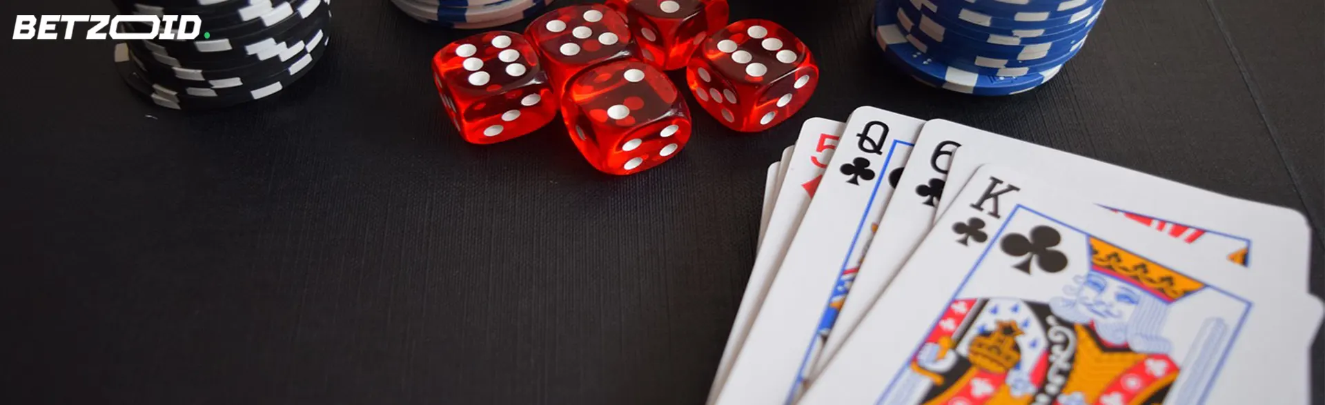 Casino chips, dice, and playing cards on a table, capturing the essence of high stakes betting sites.