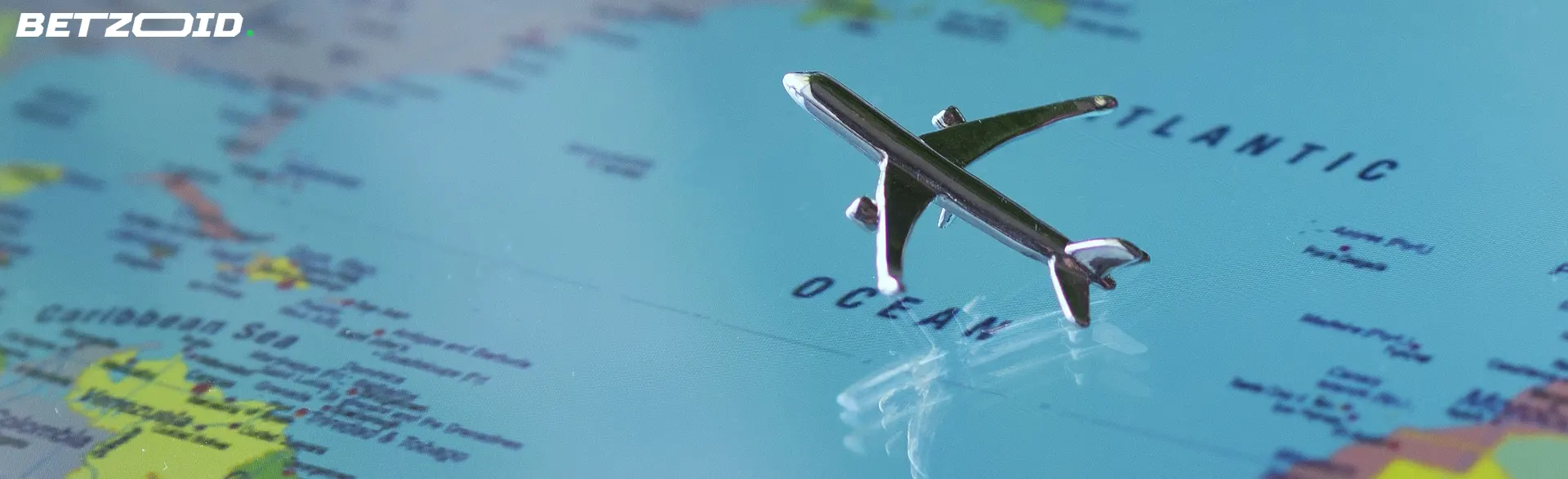 A toy airplane on a world map focused on the Atlantic Ocean, representing international sports betting sites available in Canada.