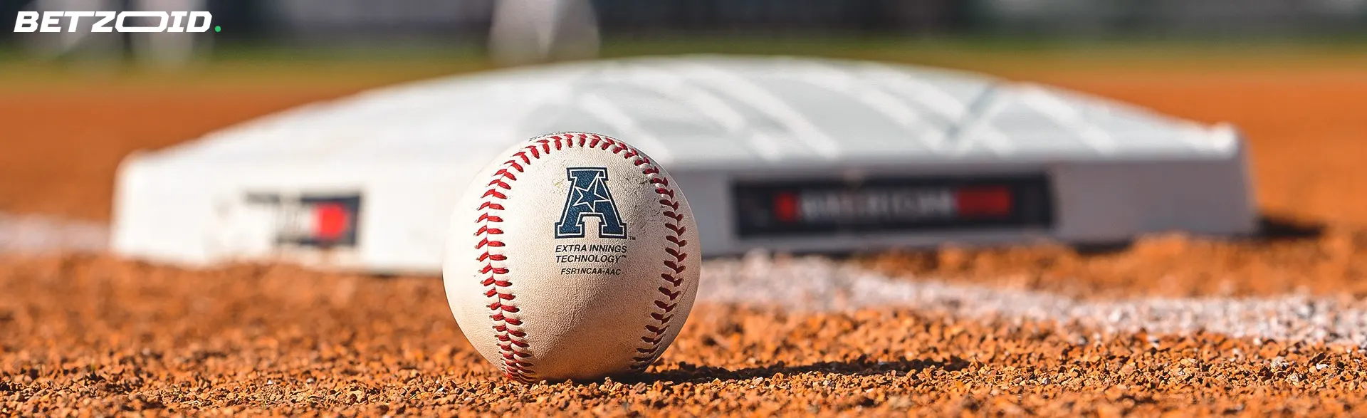 Close-up of a baseball on the field near a base, representing Saskatchewan sportsbooks.