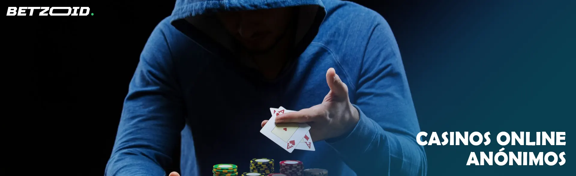 Jugador encapuchado con cartas de póker en un casino.