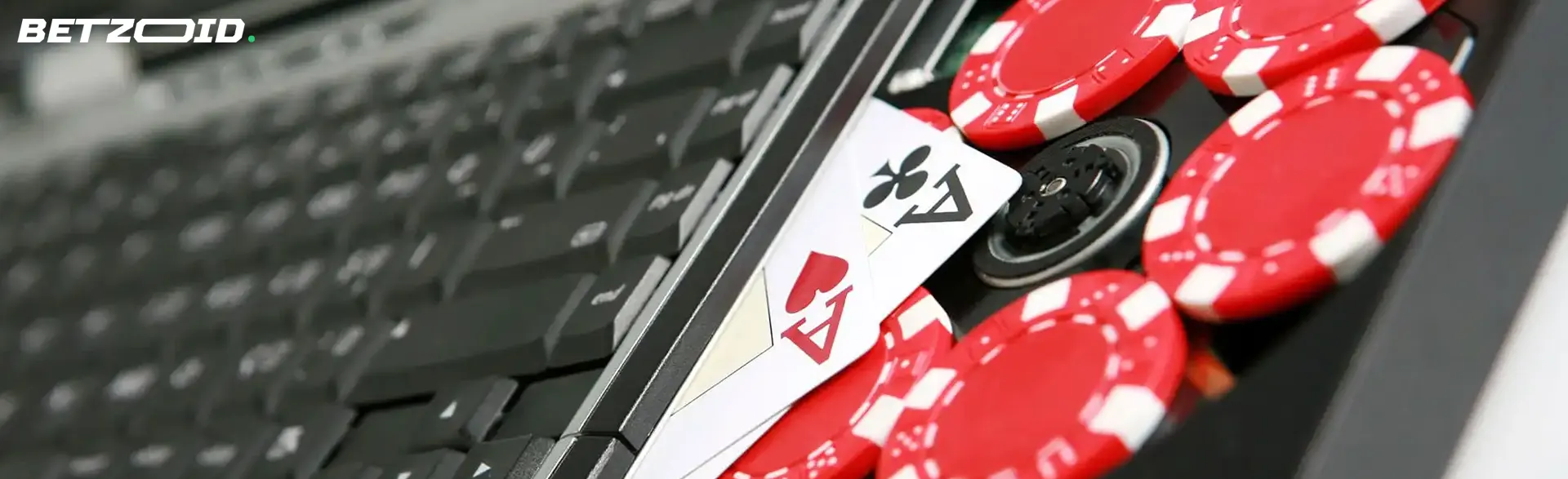 Fichas de póker sobre teclado de computadora para casinos para apuestas bajas.