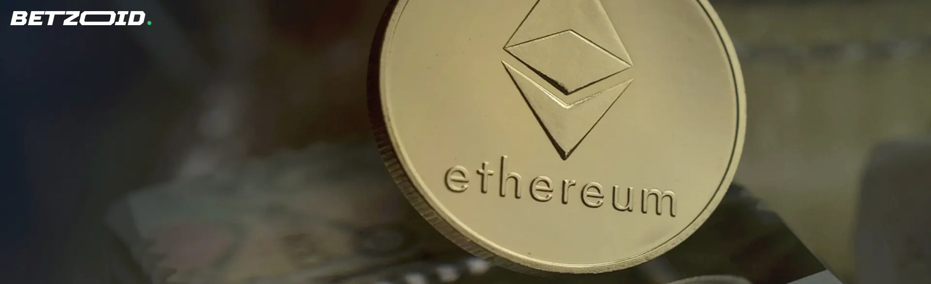 A close-up of a gold Ethereum coin with the Ethereum logo and text engraved on it.