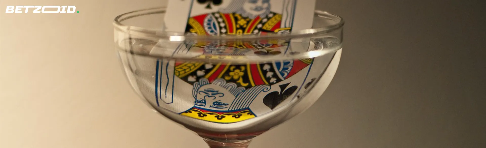 A playing card submerged in water inside a clear glass.