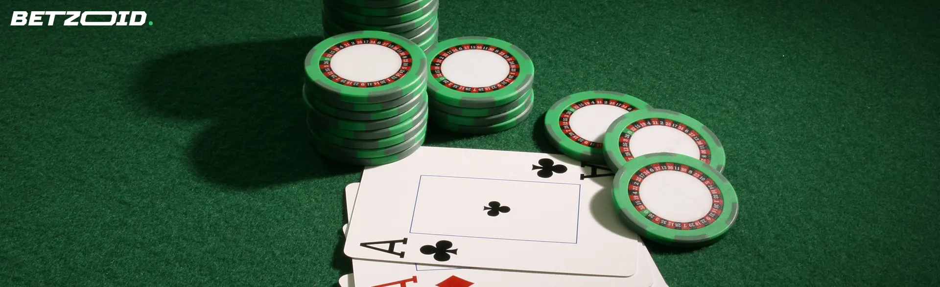 Fichas verdes y cartas sobre mesa de casinos con bonos gratis de dinero real sin depósito.