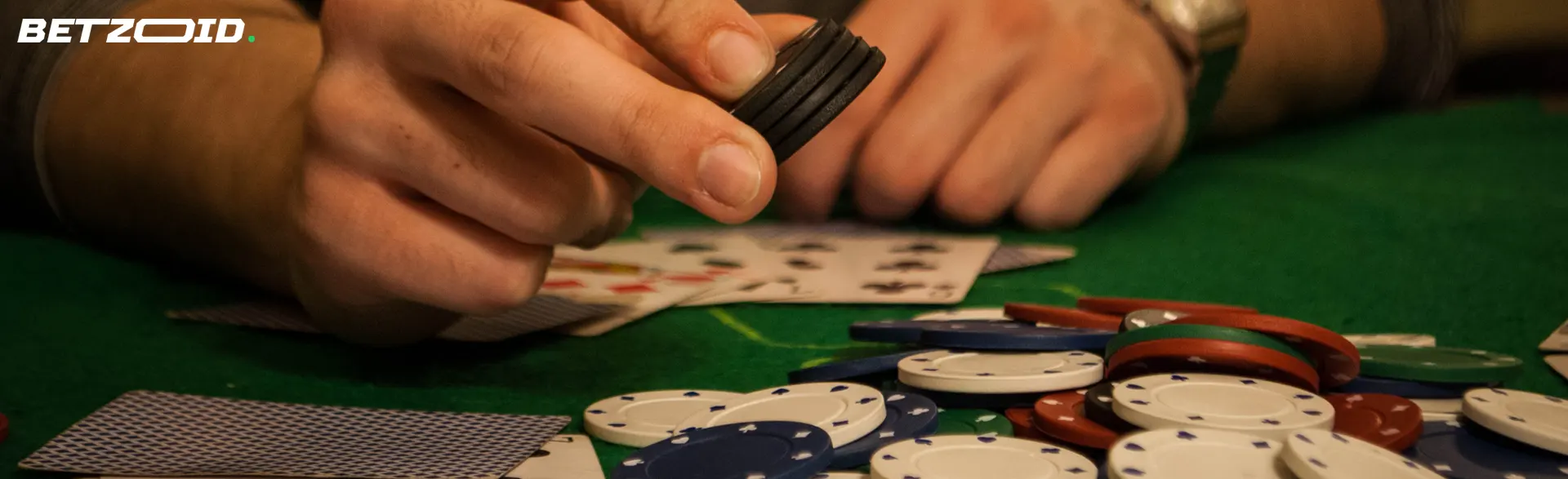 The player holds the chips on top of a stack of other chips and cards.