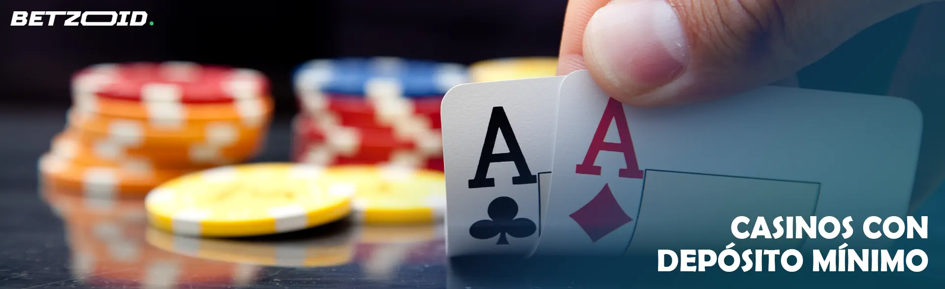 Una mano sostiene un par de ases sobre un fondo de fichas de casino.