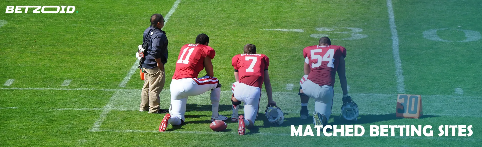 Football players on the field are preparing for the match.