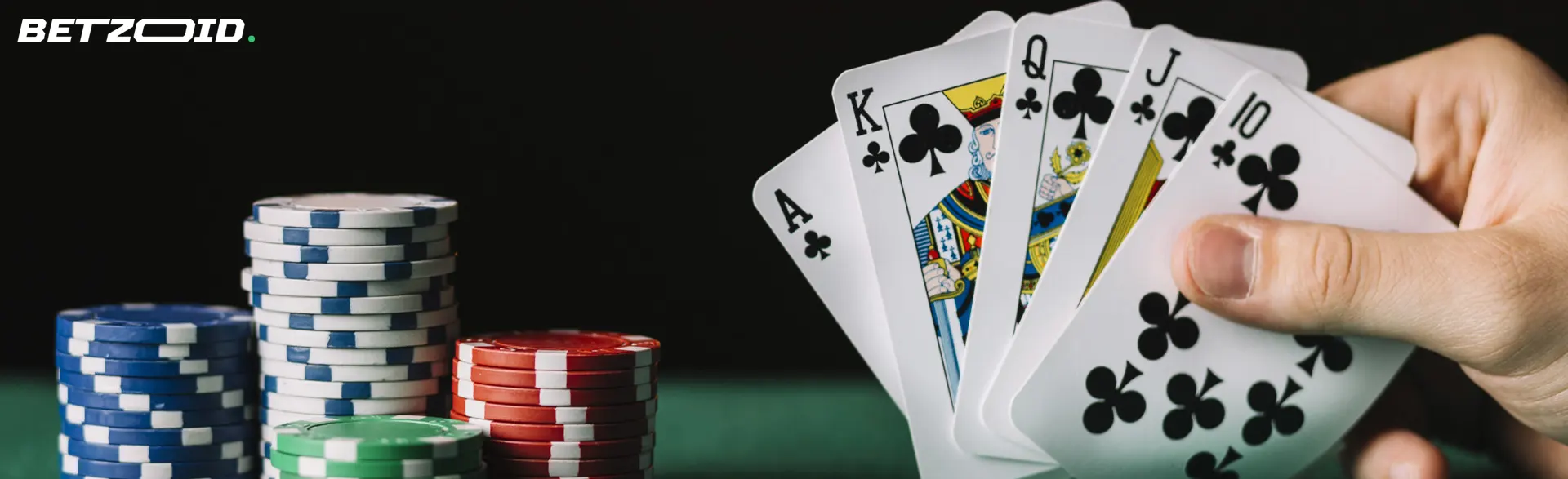 A hand holds a combination of cards next to casino chips.