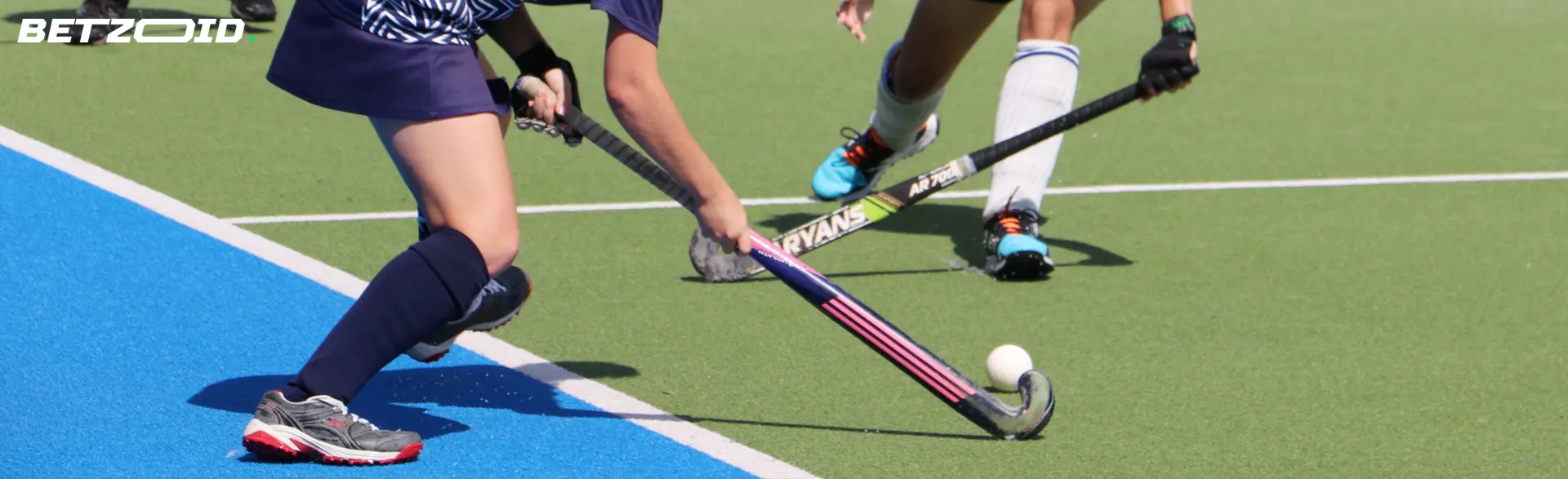 Field hockey players compete for the ball.