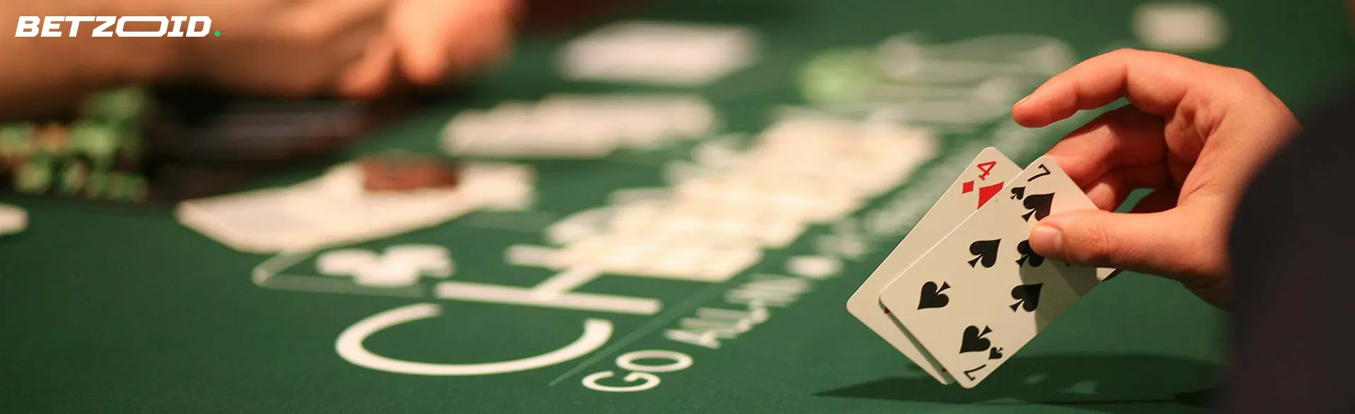 A player holds cards on the casino table.