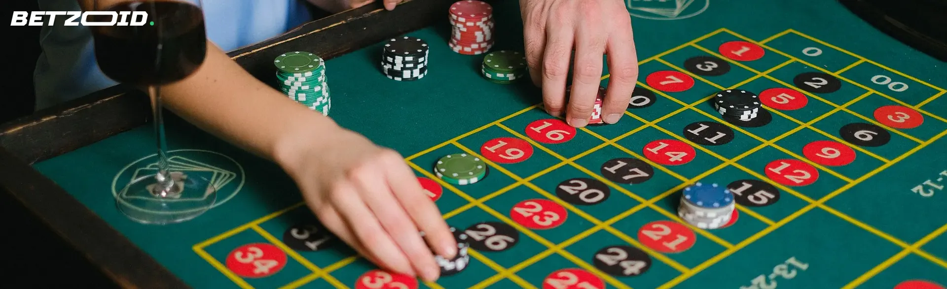 Players place bets with chips on the casino table.