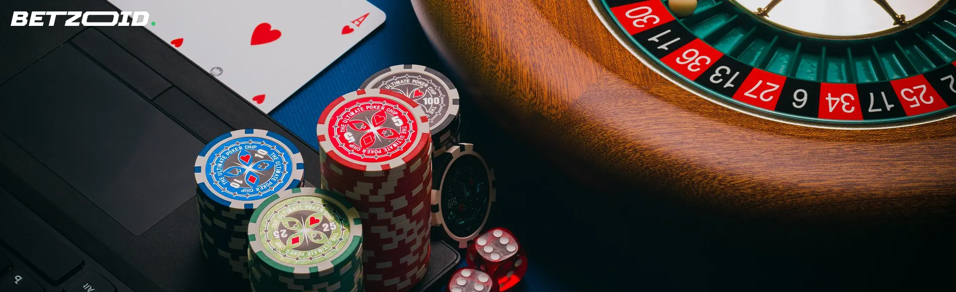 Roue de roulette et cartes à côté des jetons sur le clavier d'un ordinateur portable.