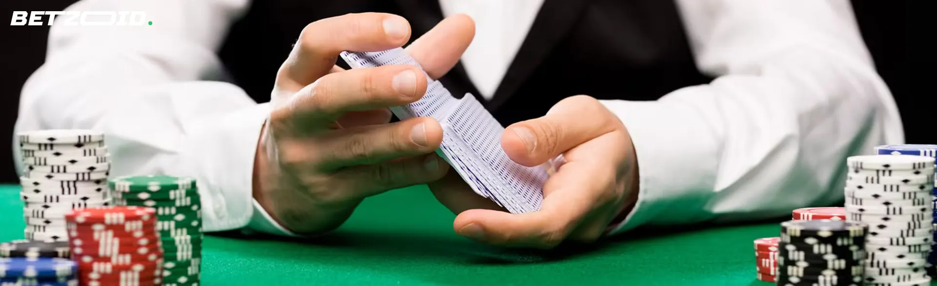 O jogador embaralha as cartas ao lado das fichas do casino.