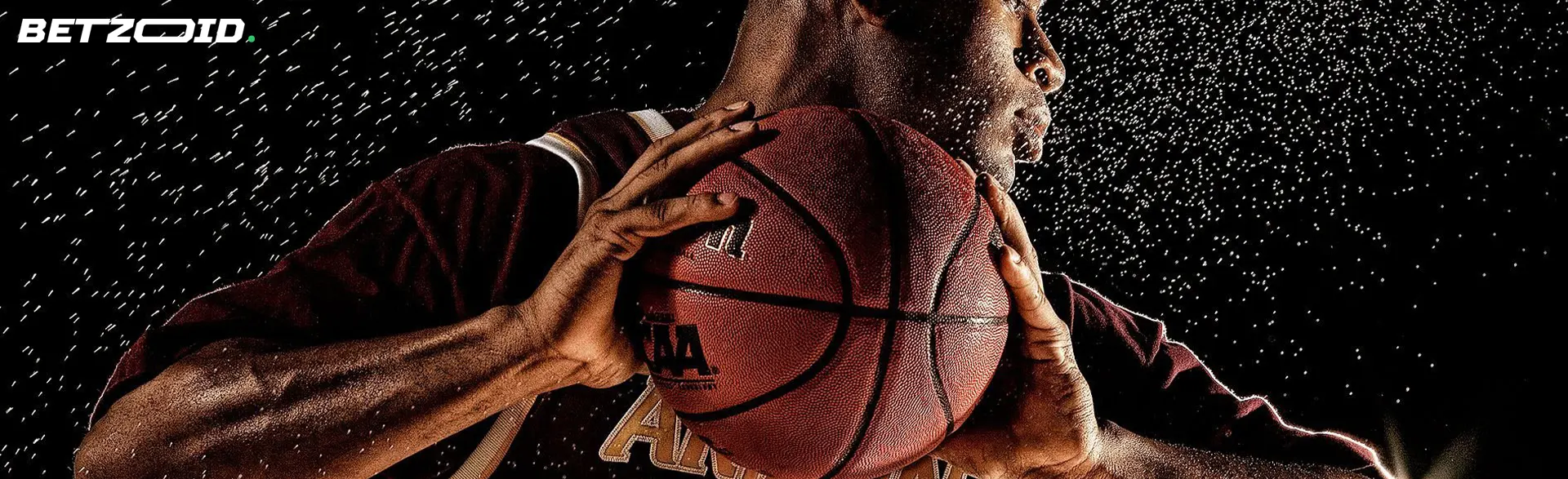 Il giocatore di basket tiene la palla su uno sfondo scuro.