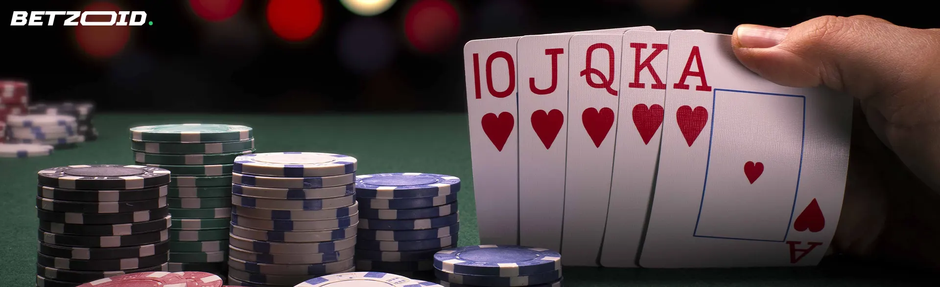 The player holds the cards next to the casino chips.