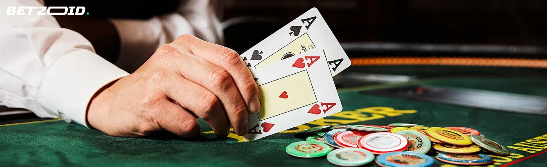 El jugador sostiene las cartas junto a las fichas del casino.