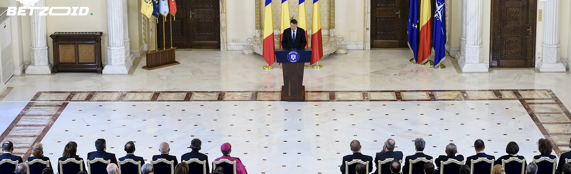 Discurs oficial al politicienilor români în sala cu steaguri.