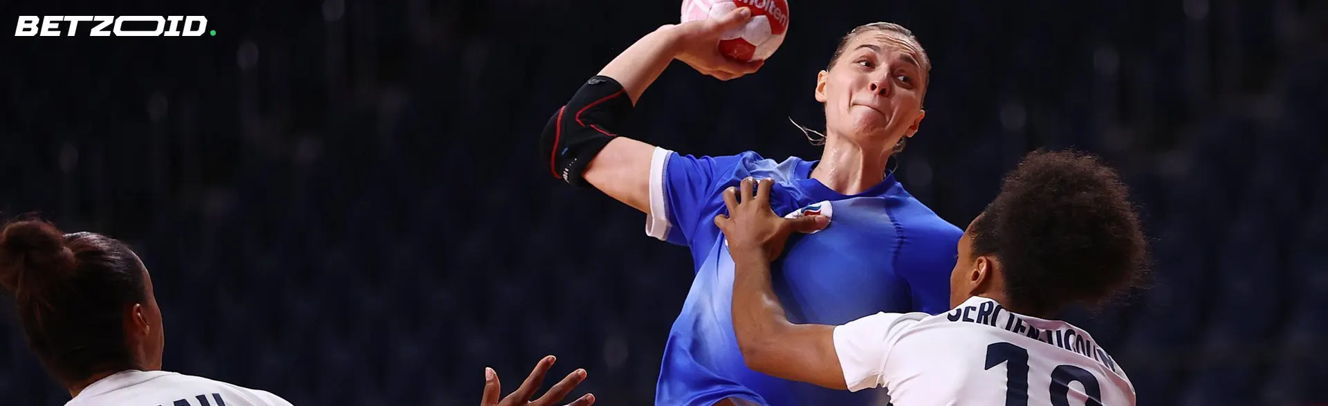 Jogador de andebol com a bola durante o jogo.