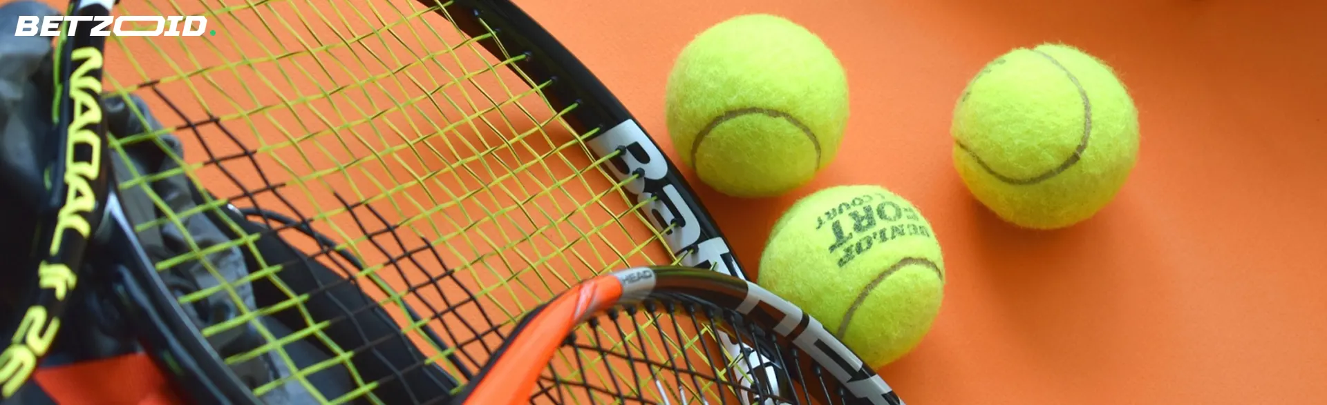 Tennisbälle neben Schlägern.