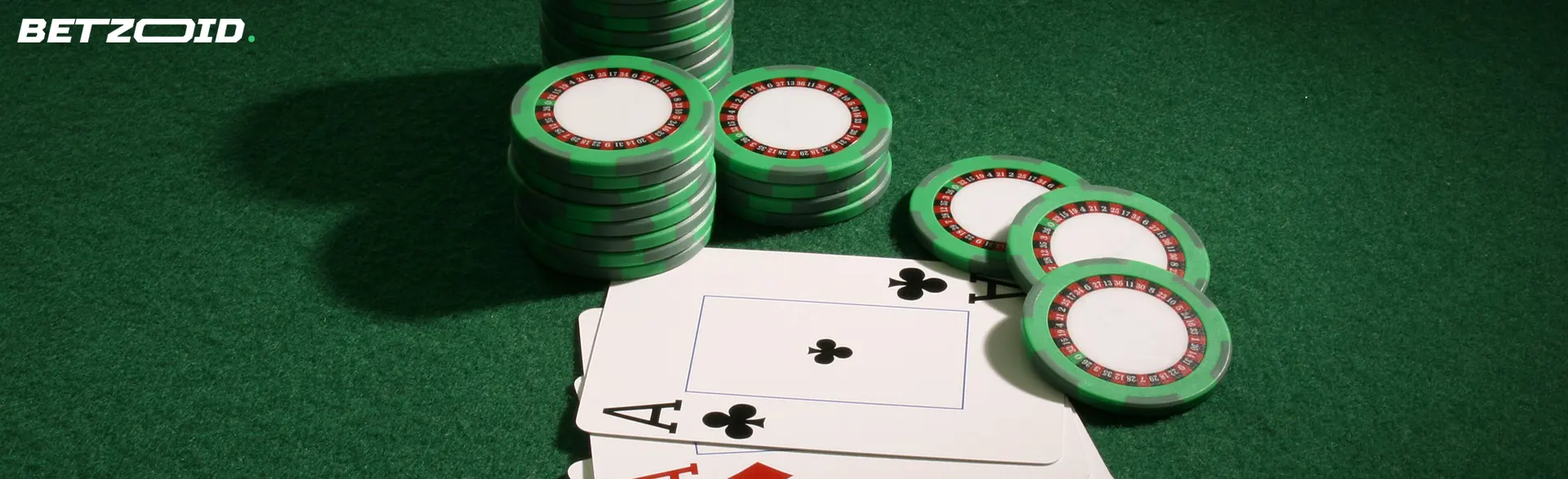 Fichas de casino numa mesa verde.
