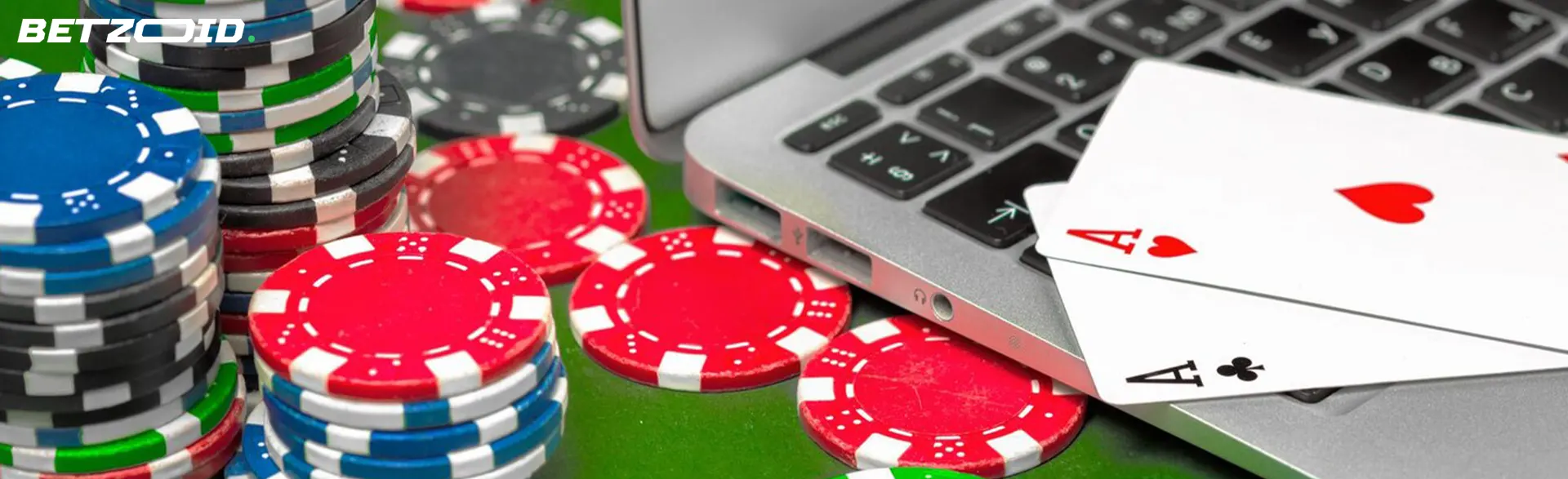 Karten auf einer Laptoptastatur neben Casino-Chips.