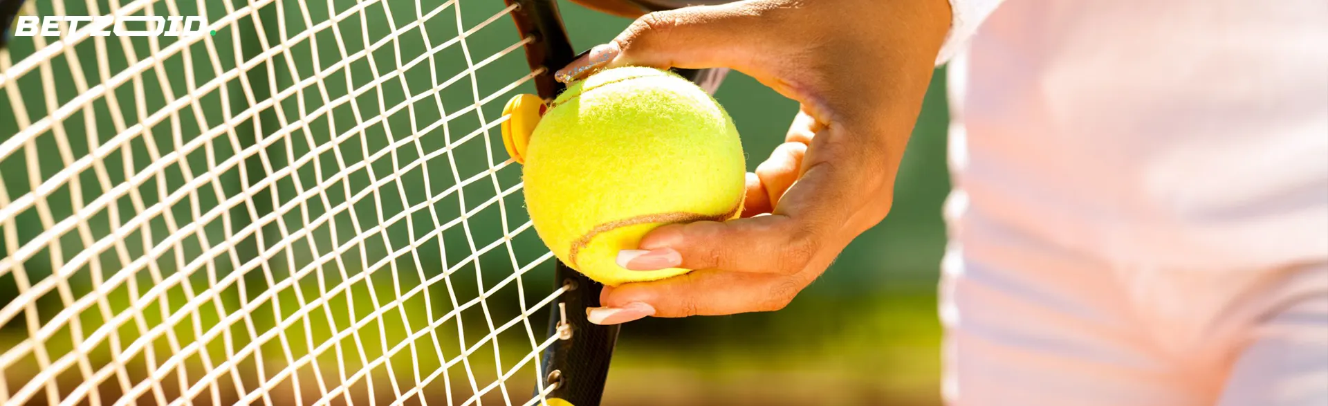 Ein Tennisspieler legt den Ball an den Schläger.
