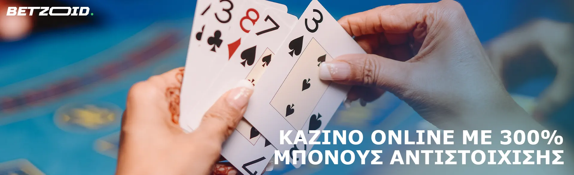 Ο παίκτης κρατά κάρτες στο φόντο του τραπεζιού του καζίνο.