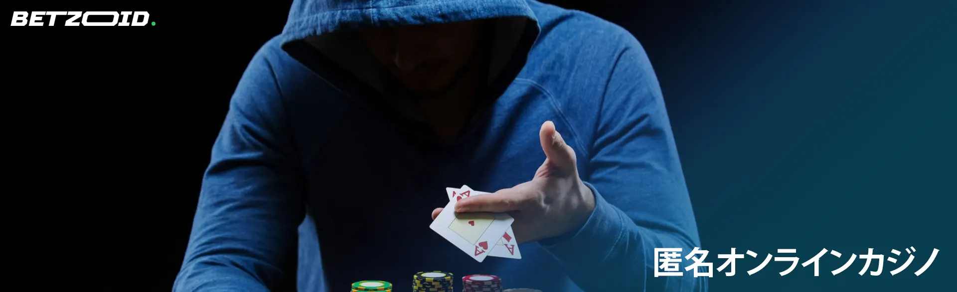 フードをかぶった男がトランプを持っています。