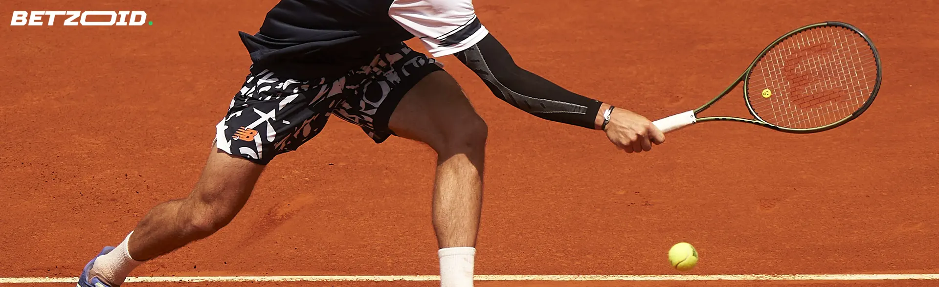 A tennis player hits the ball with a racket.