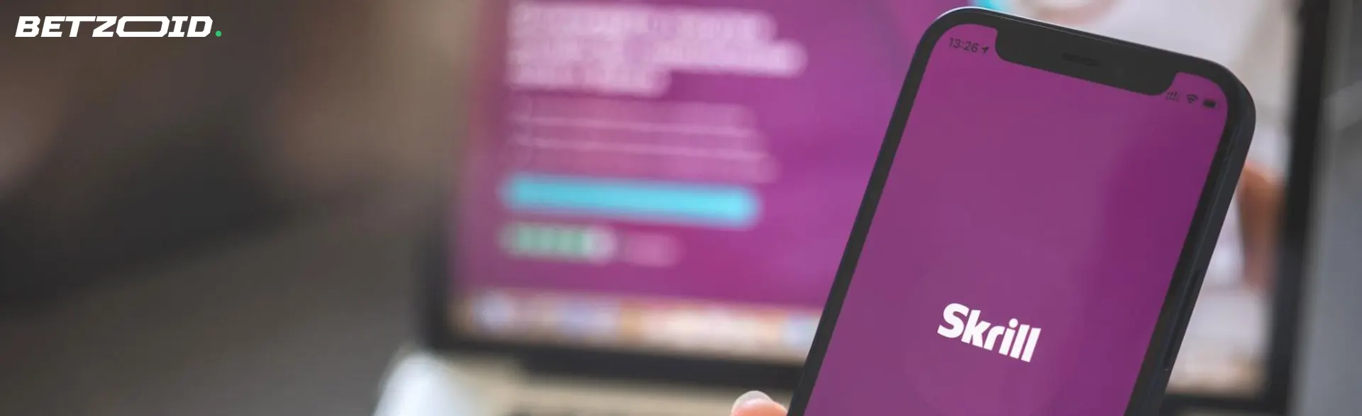 Smartphone with Skrill logo.