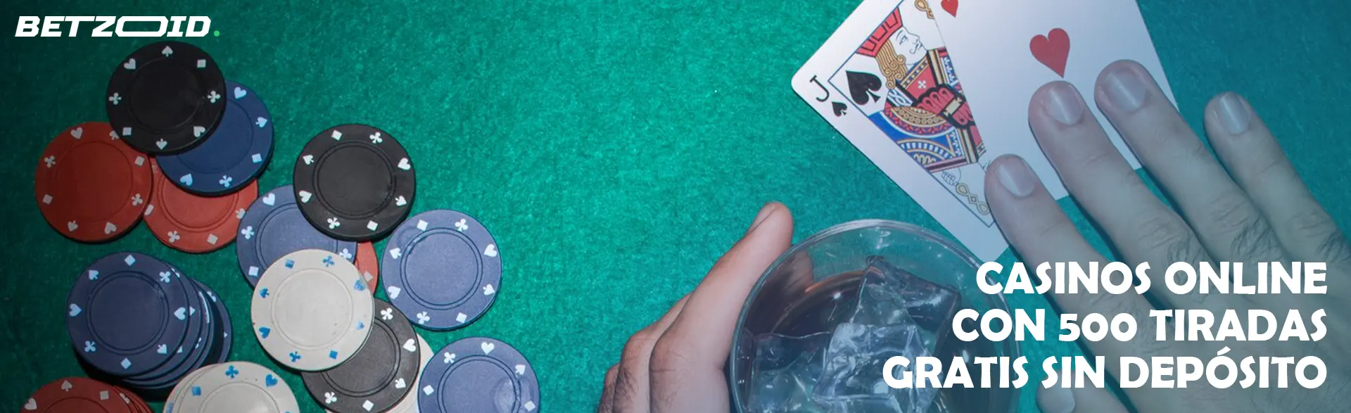 Un jugador sostiene cartas junto a una bebida en un vaso y fichas de casino.