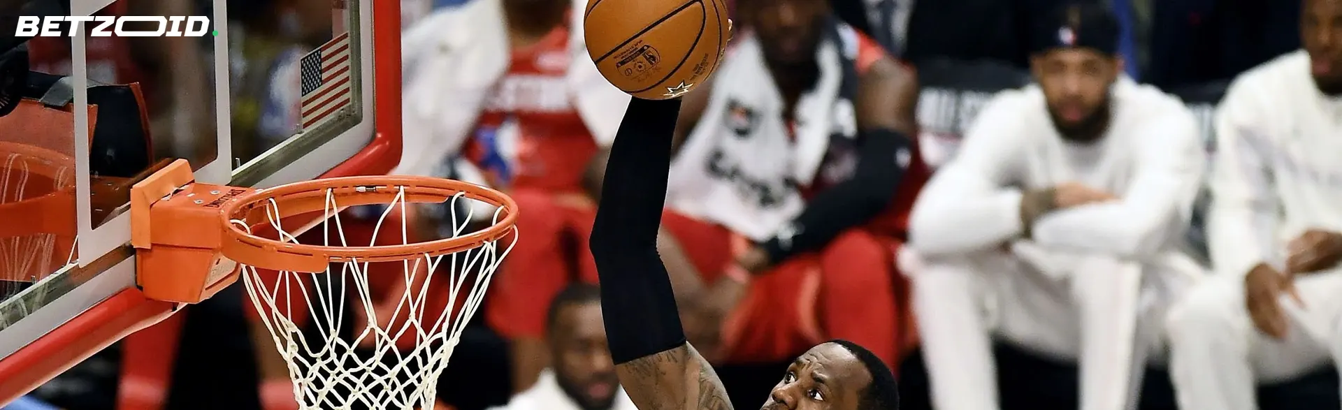 Un jugador de baloncesto lanza la pelota a la canasta.