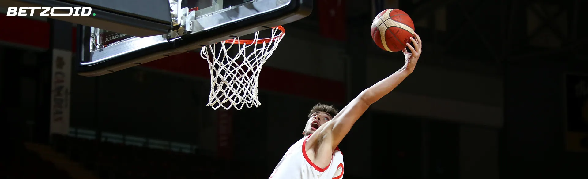 Un jugador de baloncesto lanza la pelota a la canasta.