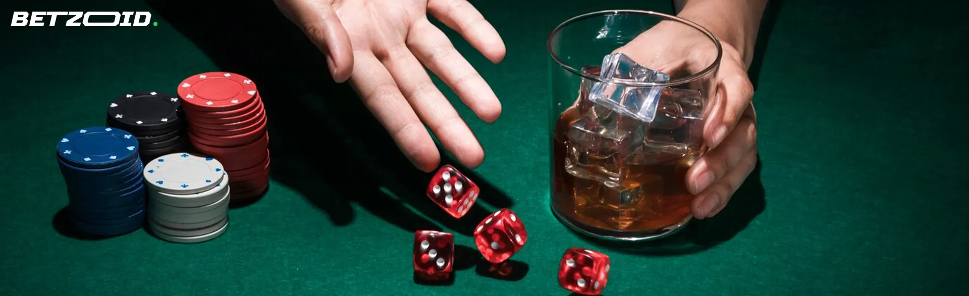 A player rolls dice next to casino chips and a drink in a glass.