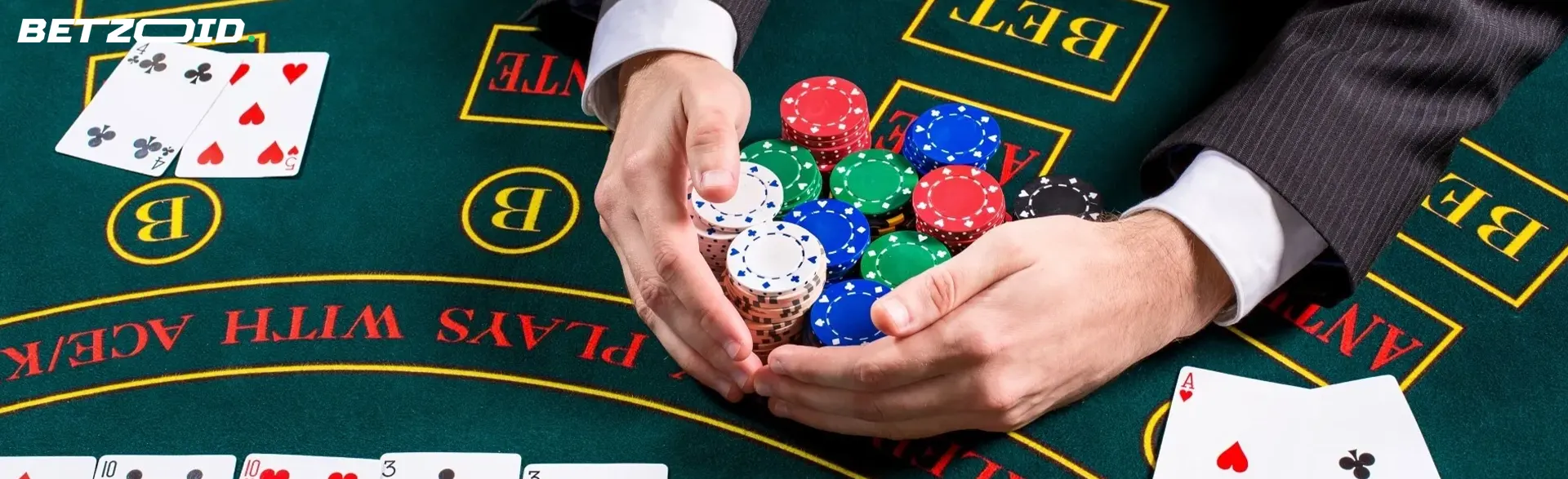 A player holds a pile of chips on a casino table.