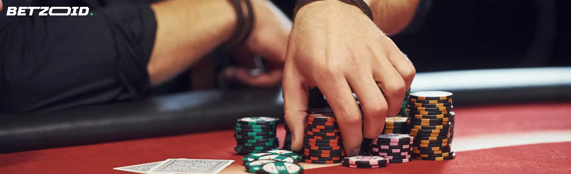 A player holds chips on a casino table.
