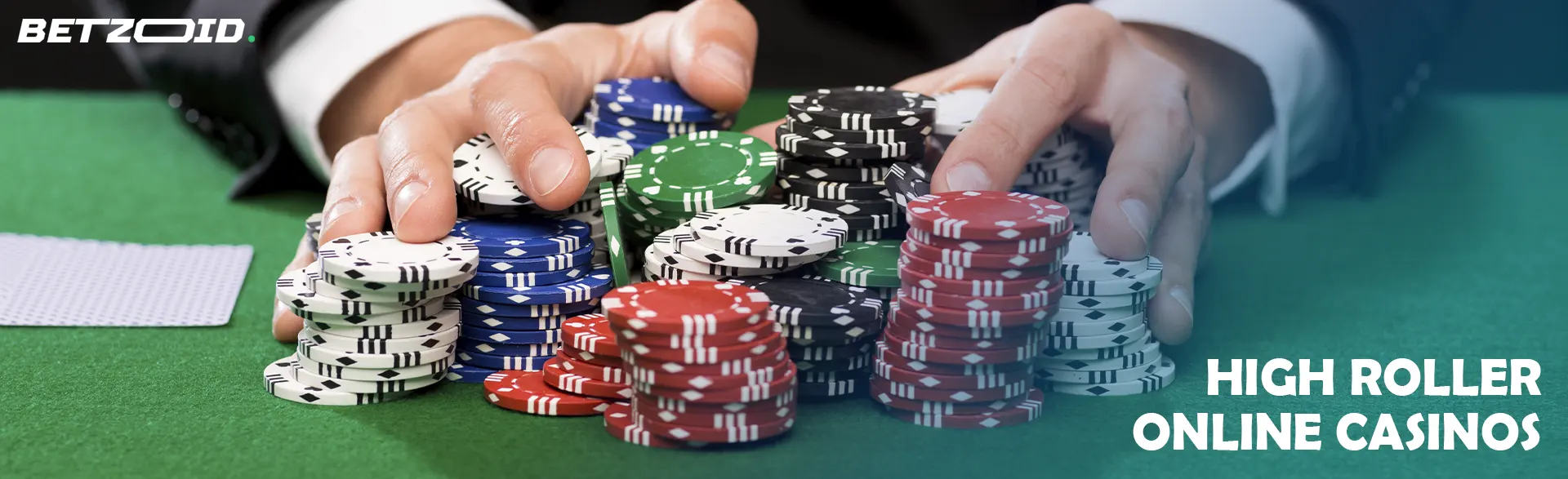 A player holds a pile of chips on a casino table.